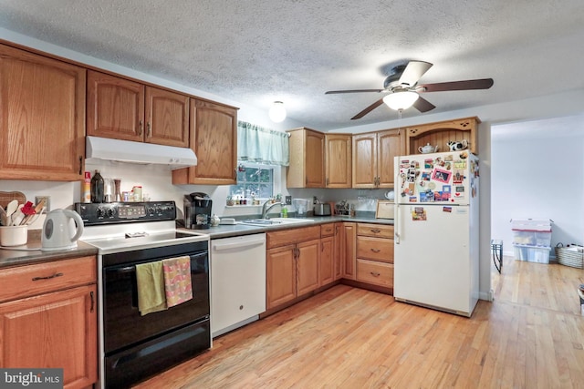 kitchen with a textured ceiling, sink, light hardwood / wood-style flooring, and white appliances