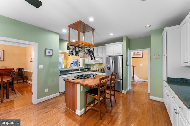 kitchen with dishwasher, light hardwood / wood-style floors, a breakfast bar, white cabinetry, and stainless steel fridge with ice dispenser