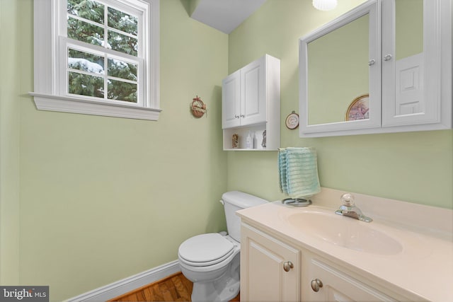 bathroom featuring toilet, wood-type flooring, and vanity