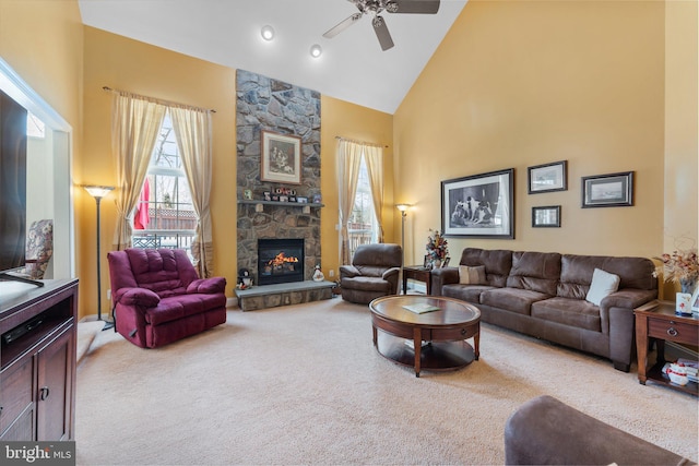 carpeted living room with high vaulted ceiling, ceiling fan, and a fireplace