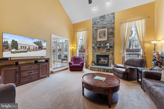 carpeted living room featuring high vaulted ceiling and a stone fireplace