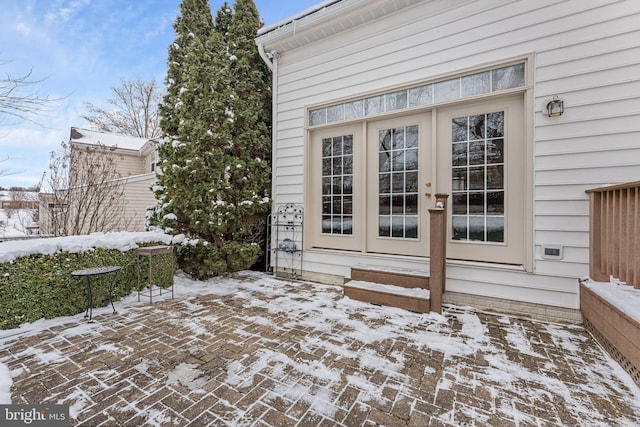 snow covered property entrance with french doors