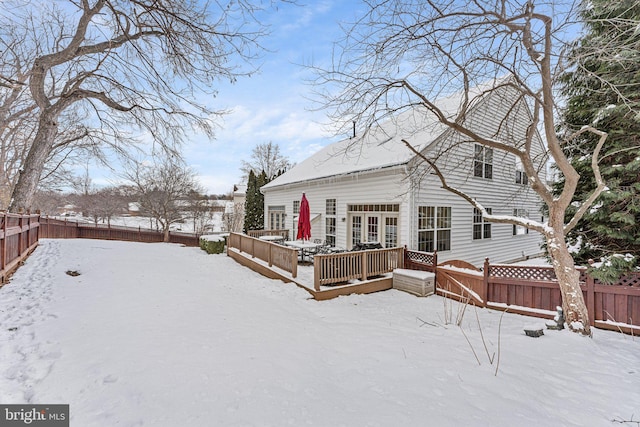 snow covered property with a deck