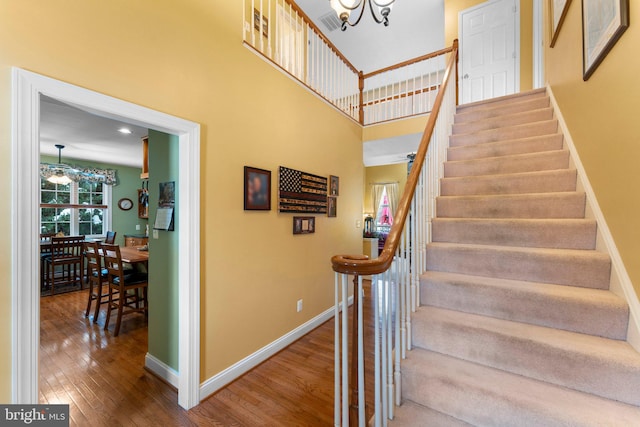 stairs with a chandelier and wood-type flooring