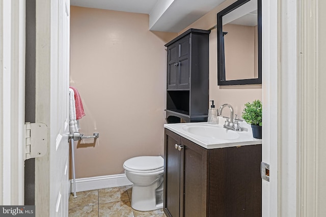 bathroom featuring toilet, tile patterned flooring, and vanity