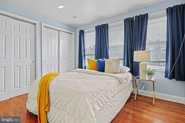 bedroom featuring multiple closets and wood-type flooring