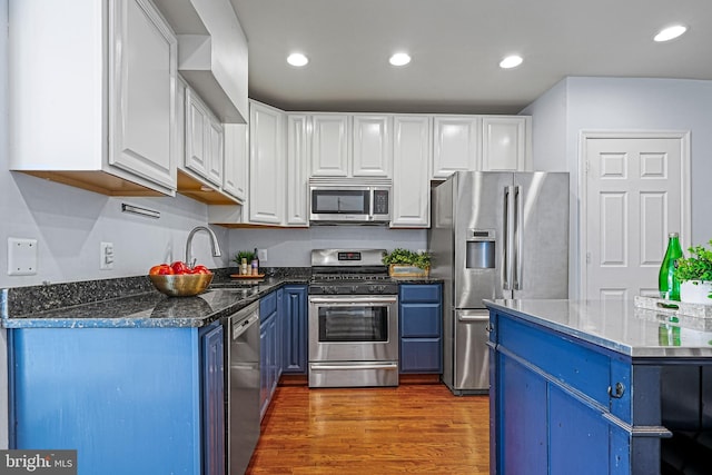 kitchen featuring sink, blue cabinets, white cabinets, appliances with stainless steel finishes, and dark wood-type flooring