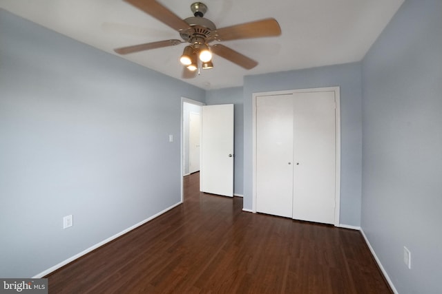 unfurnished bedroom with ceiling fan, dark wood-type flooring, and a closet