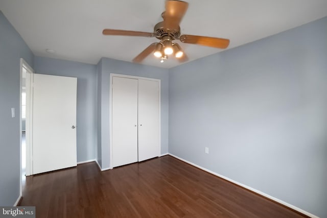 unfurnished bedroom with ceiling fan, a closet, and dark wood-type flooring