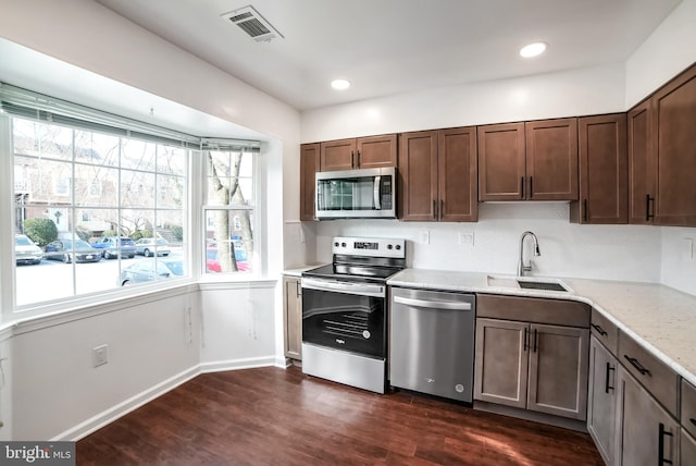 kitchen with dark brown cabinetry, a wealth of natural light, sink, stainless steel appliances, and dark hardwood / wood-style floors