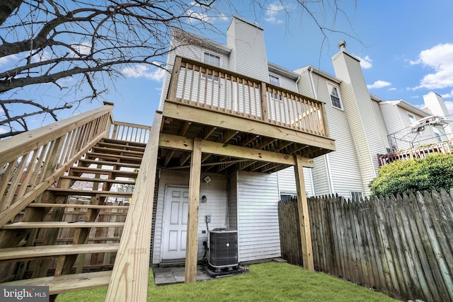 rear view of house featuring central air condition unit and a wooden deck