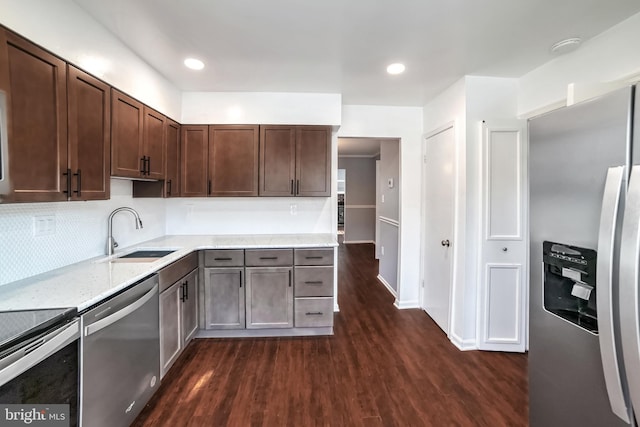 kitchen featuring dark hardwood / wood-style flooring, light stone counters, dark brown cabinetry, stainless steel appliances, and sink