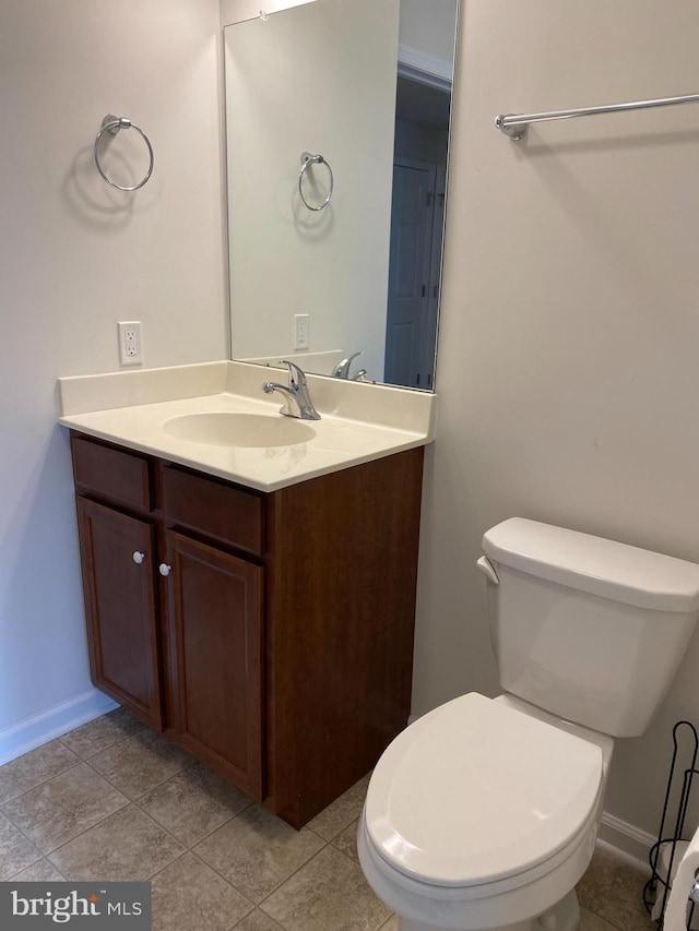 bathroom with toilet, tile patterned flooring, and vanity