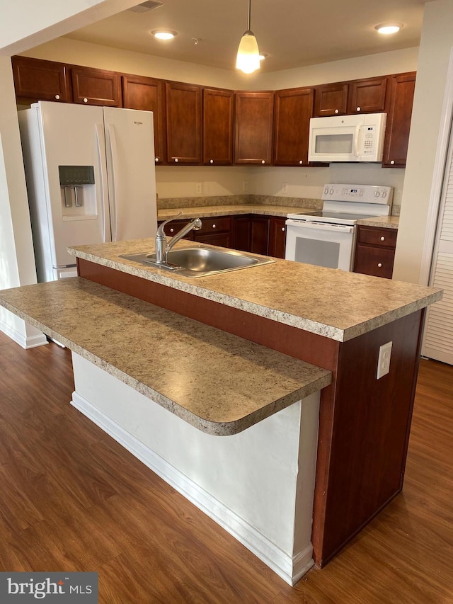 kitchen with sink, white appliances, hanging light fixtures, and dark wood-type flooring