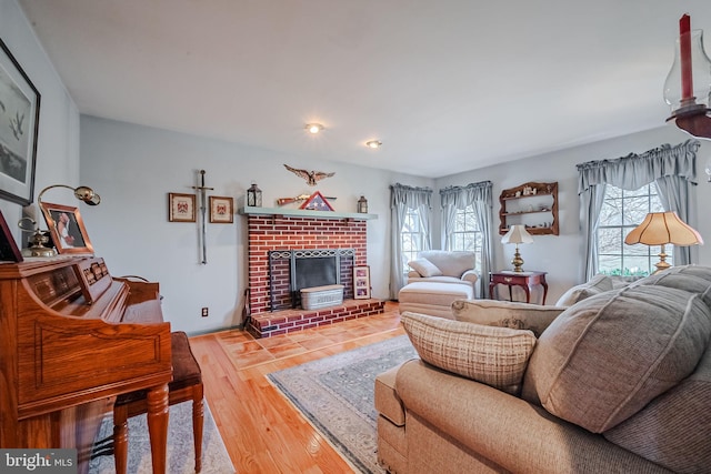 living room featuring hardwood / wood-style flooring and a brick fireplace