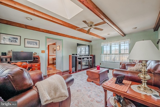 living room featuring beamed ceiling and ceiling fan