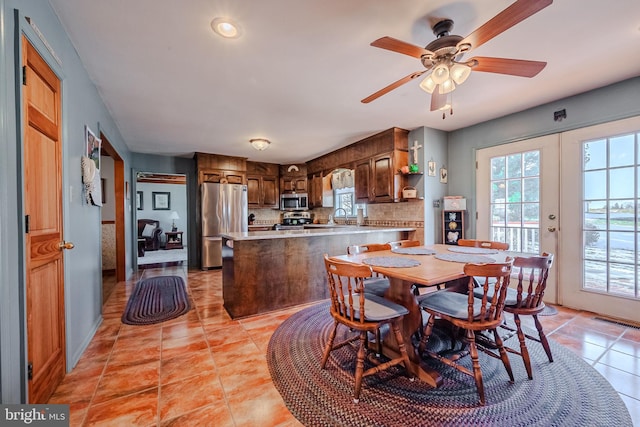 tiled dining area featuring ceiling fan, french doors, and sink