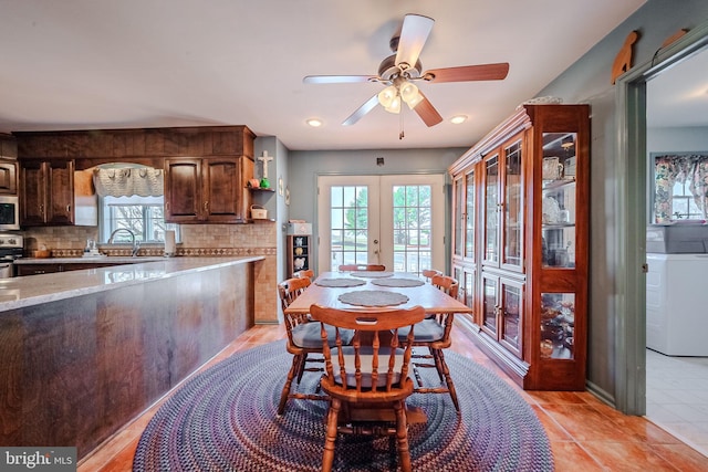 tiled dining area with ceiling fan, french doors, and sink