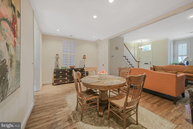 dining area with stairway, baseboards, light wood-style flooring, and crown molding