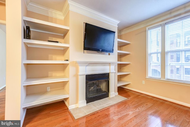 unfurnished living room featuring hardwood / wood-style floors, crown molding, and a fireplace