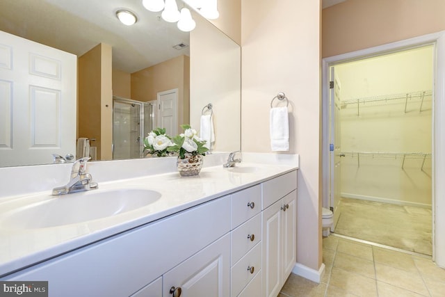 bathroom with tile patterned floors, vanity, toilet, and an enclosed shower