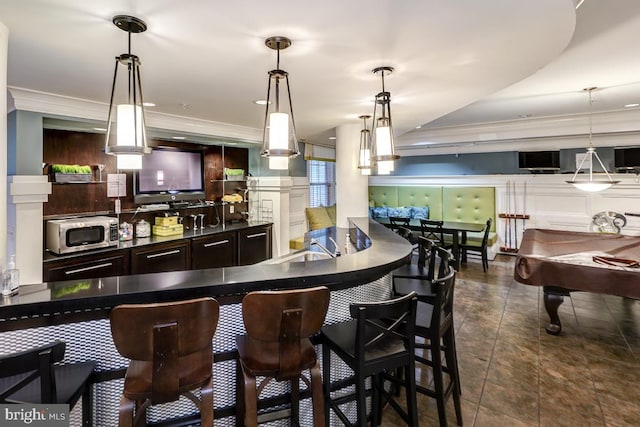 bar with pendant lighting, dark brown cabinetry, ornamental molding, and billiards