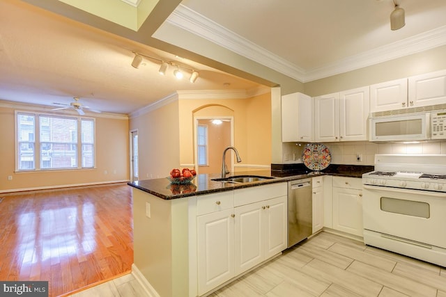 kitchen with white cabinets, white appliances, kitchen peninsula, and sink