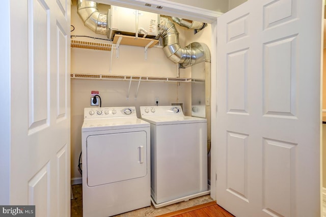 laundry area featuring wood-type flooring and separate washer and dryer