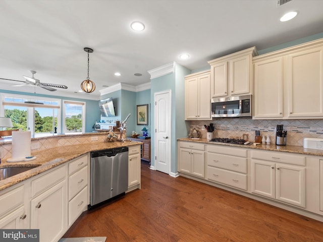 kitchen with light stone counters, stainless steel appliances, ceiling fan, dark wood-type flooring, and hanging light fixtures