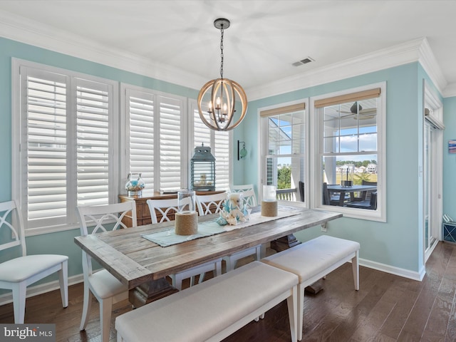 dining space with dark hardwood / wood-style floors, ornamental molding, and an inviting chandelier