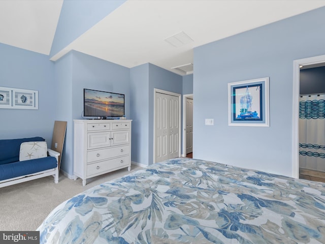 carpeted bedroom with a closet and vaulted ceiling