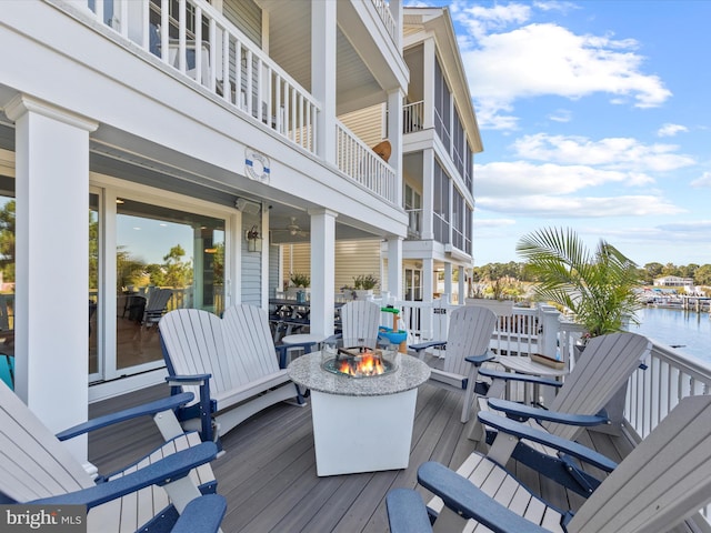 deck with a water view and an outdoor fire pit