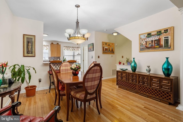 dining area featuring light hardwood / wood-style flooring and a chandelier