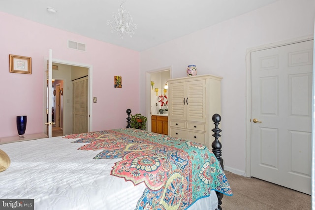 carpeted bedroom featuring an inviting chandelier