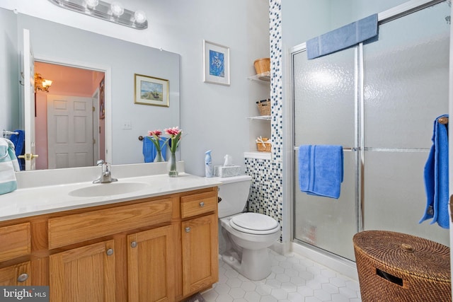 bathroom featuring tile patterned floors, vanity, toilet, and a shower with door