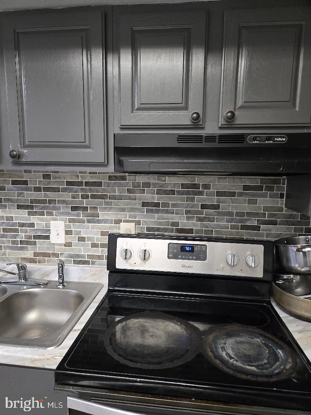 kitchen with decorative backsplash, sink, extractor fan, and black range with electric cooktop