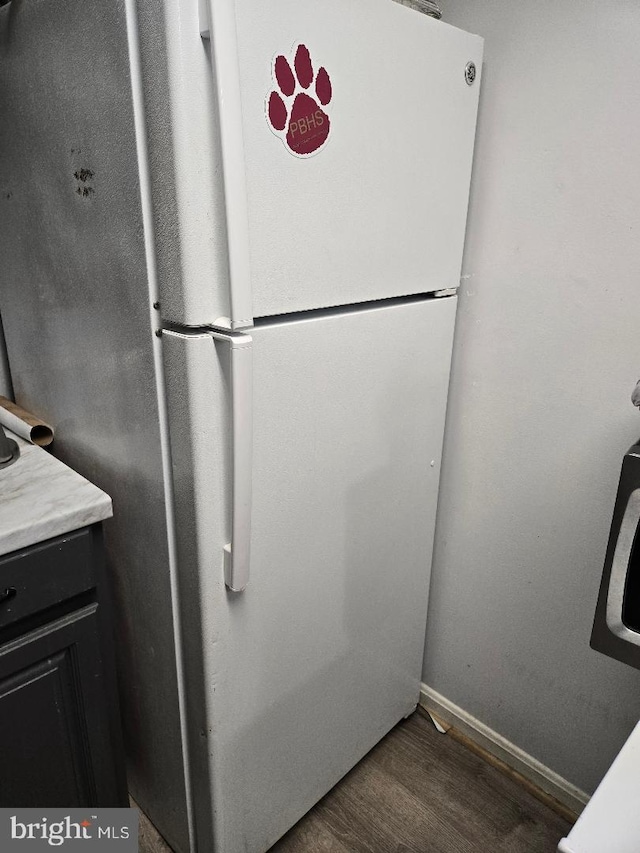 interior details with white fridge and dark hardwood / wood-style floors