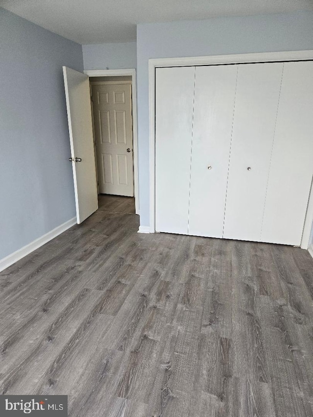 unfurnished bedroom featuring wood-type flooring and a closet