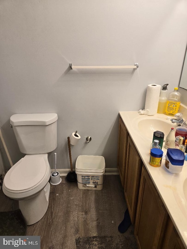 bathroom with hardwood / wood-style flooring, vanity, and toilet