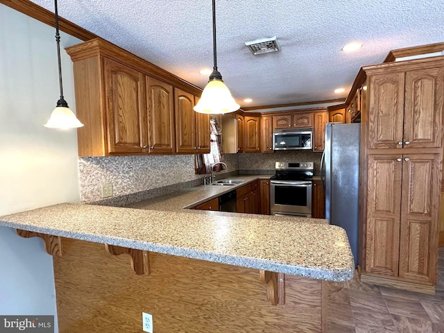 kitchen featuring appliances with stainless steel finishes, a breakfast bar, and a peninsula