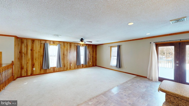 unfurnished living room with plenty of natural light, visible vents, and french doors