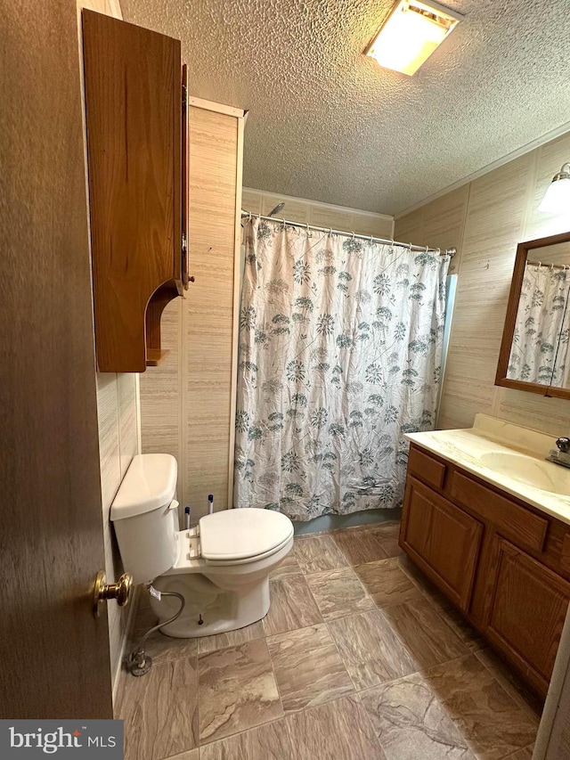 full bath featuring toilet, a textured ceiling, a shower with shower curtain, and vanity