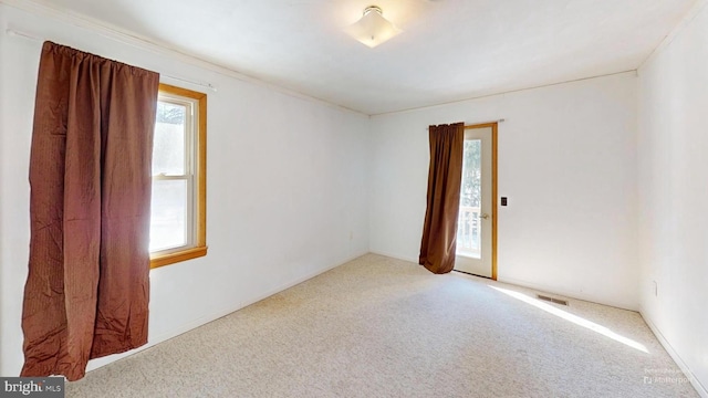 carpeted empty room featuring visible vents