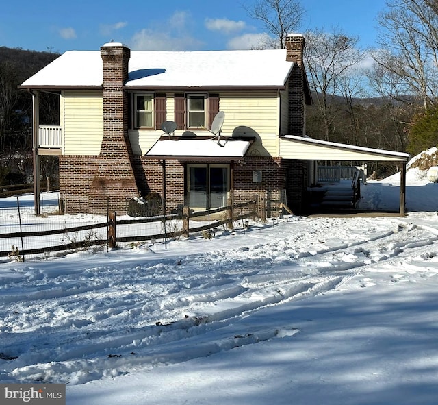 view of front of home featuring a chimney and brick siding