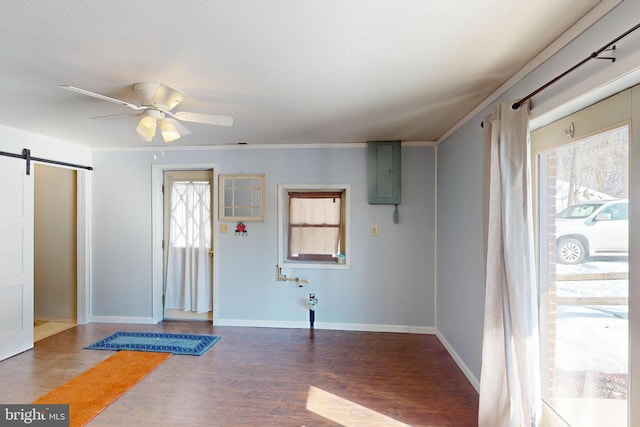 foyer featuring ceiling fan, a barn door, baseboards, electric panel, and dark wood finished floors