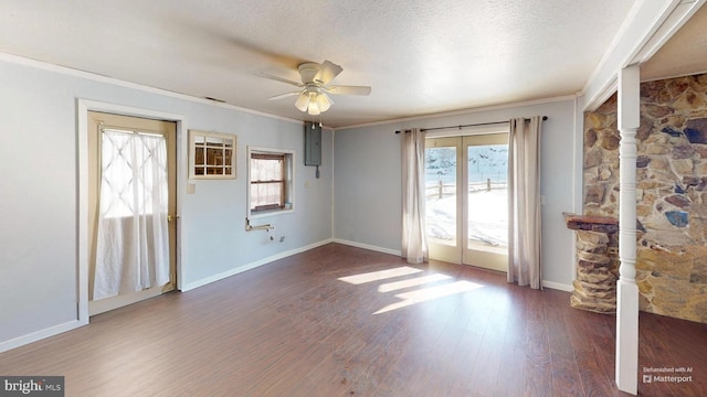 unfurnished room featuring dark wood finished floors, ornamental molding, a ceiling fan, a textured ceiling, and baseboards