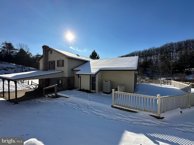 snow covered house with fence