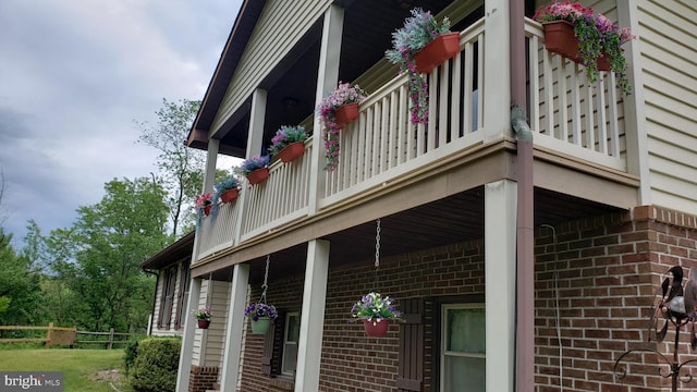 view of property exterior featuring brick siding and a balcony