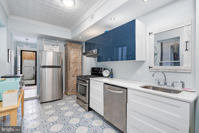 kitchen featuring stainless steel appliances, sink, white cabinets, wall chimney exhaust hood, and ornamental molding