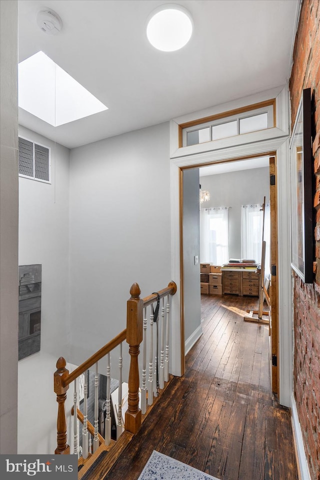 corridor featuring a skylight and dark hardwood / wood-style floors